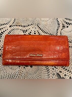 Miu Miu orange crocodile embossed leather long wallet.